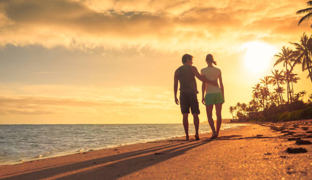 Couple walking on the beach and watching a beautiful sunset in Maui